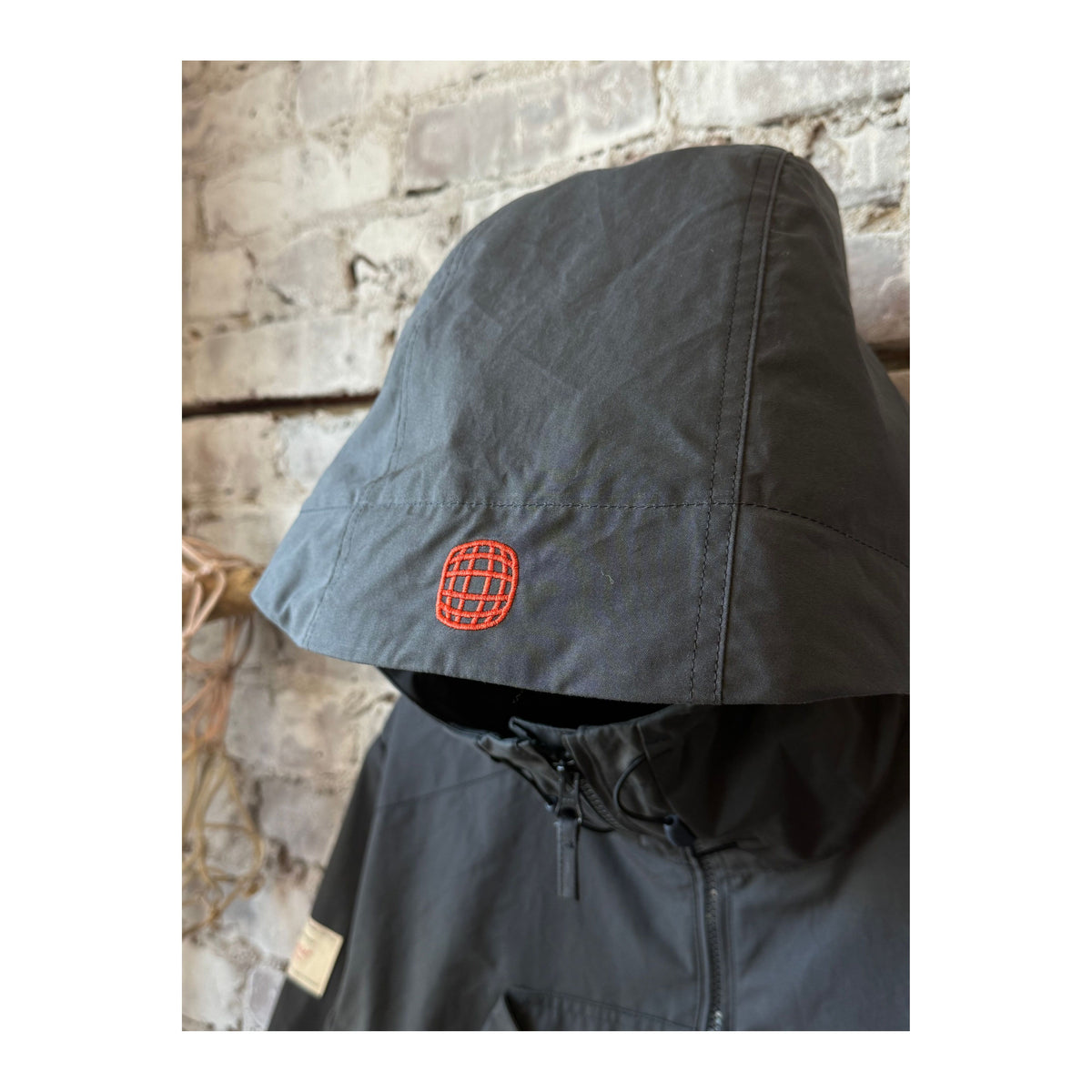 Men's Vidda Unisex Charcoal Jacket by Amundsen, shown in a stylish outdoor setting, highlighting the jacket's durable fabric and design.