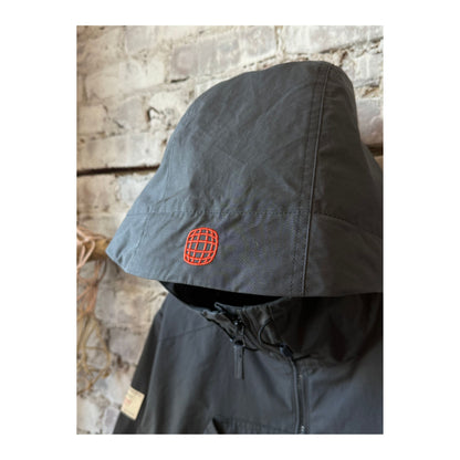 Men's Vidda Unisex Charcoal Jacket by Amundsen, shown in a stylish outdoor setting, highlighting the jacket's durable fabric and design.
