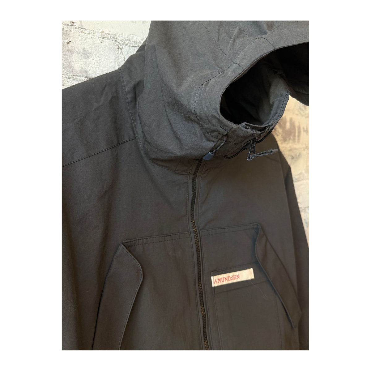 Men's Amundsen Vidda Unisex Charcoal Jacket hanging on a hanger, showcasing its durable fabric and modern outdoor style.