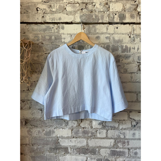 Women's violet top by Secular featuring a stylish blue design, showcased on a hanger with a simple background.