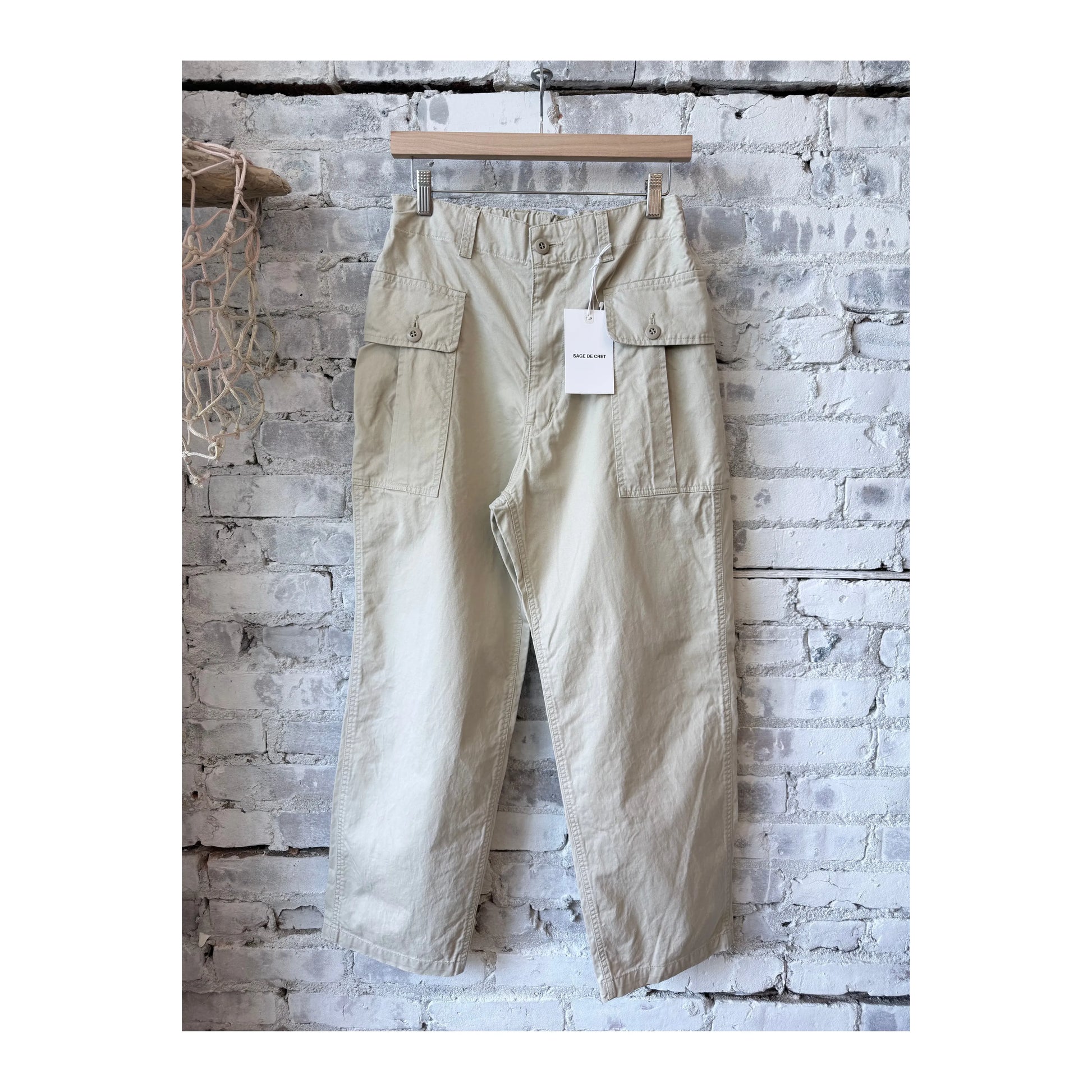 Men's beige wide chino cloth cargo pant by Sage De Cret, featuring multiple pockets and relaxed fit, shown on a model.