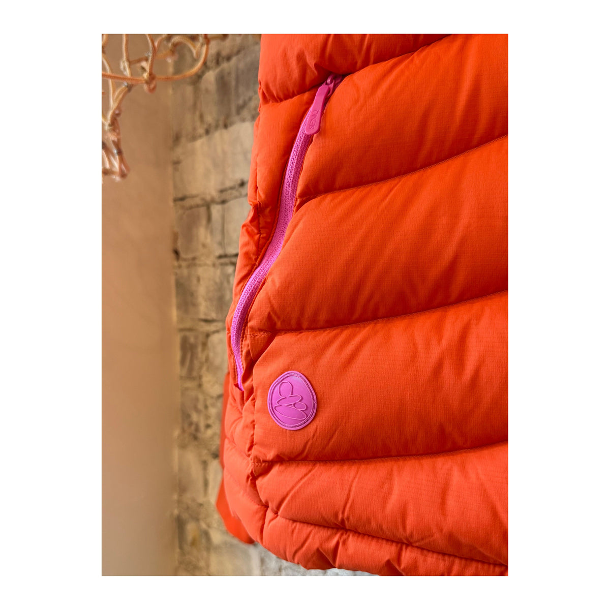 Women's Wildpuff Packable Removable Hood Jacket by Seniq in spicy color, showing the jacket's lightweight fabric and hood details.