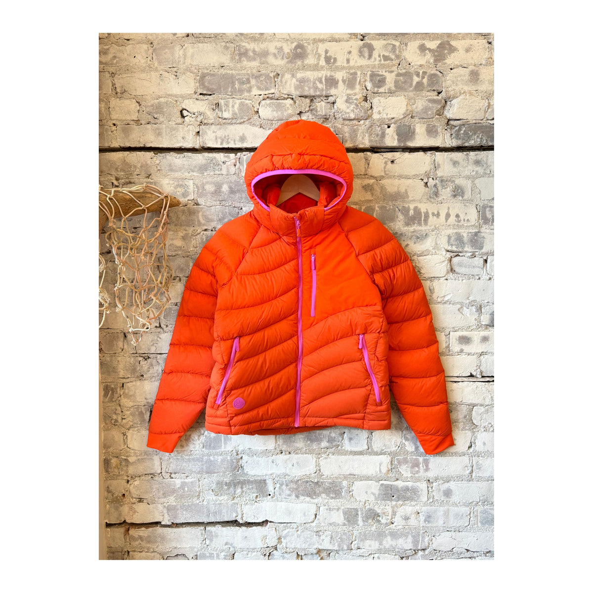 Women's Wildpuff Packable Removable Hood Jacket by Seniq in spicy color, showing the lightweight, insulated jacket with hood and packable design.