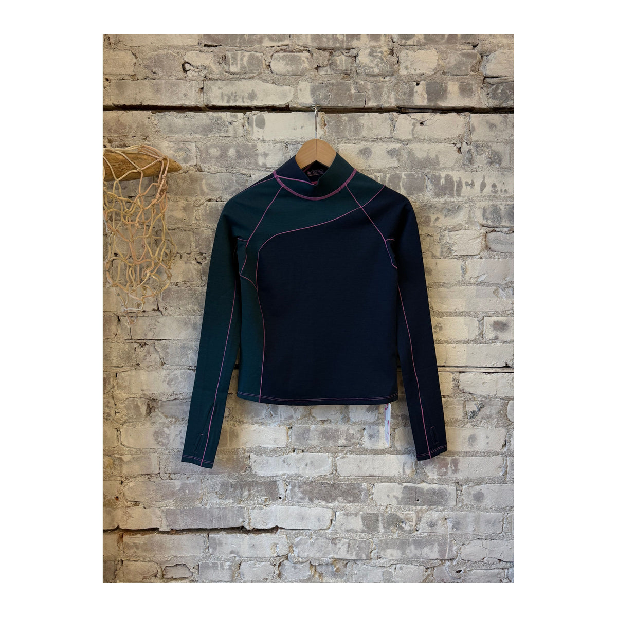 Women's Wool Sculpt Merino Mock Neck sweater by Seniq, featuring a close-up of the soft, fitted mock neck in neutral wool fabric.