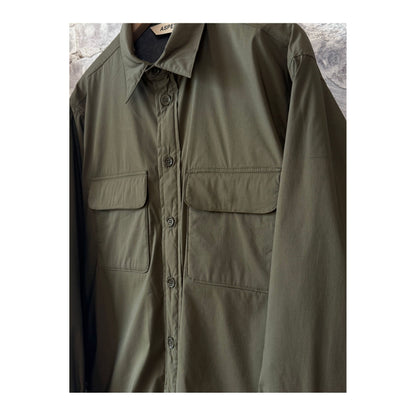 Men's Aspesi Yoshitaka Cotton/Nylon Military Shirt Jacket hanging on a hanger, showcasing its rugged fabric and military-inspired design.