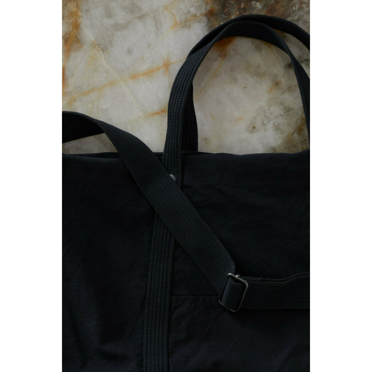 Black cotton canvas tote bag from Closed Men's accessories collection, showing sturdy handles and spacious interior.